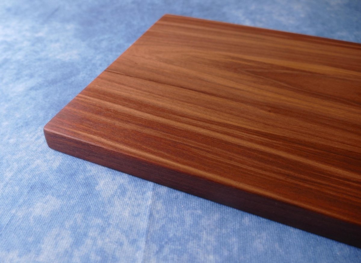 black walnut cutting board on a blue background