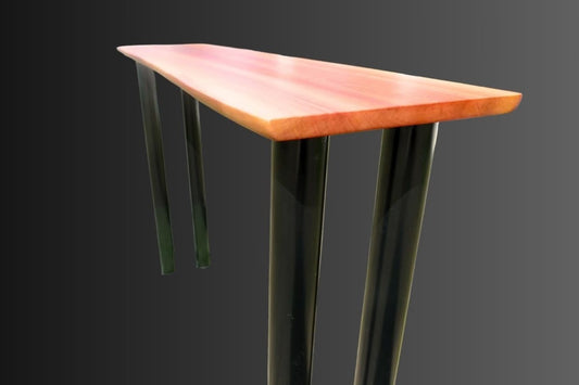 a close up of a pink redheart hardwood table with black round metal legs