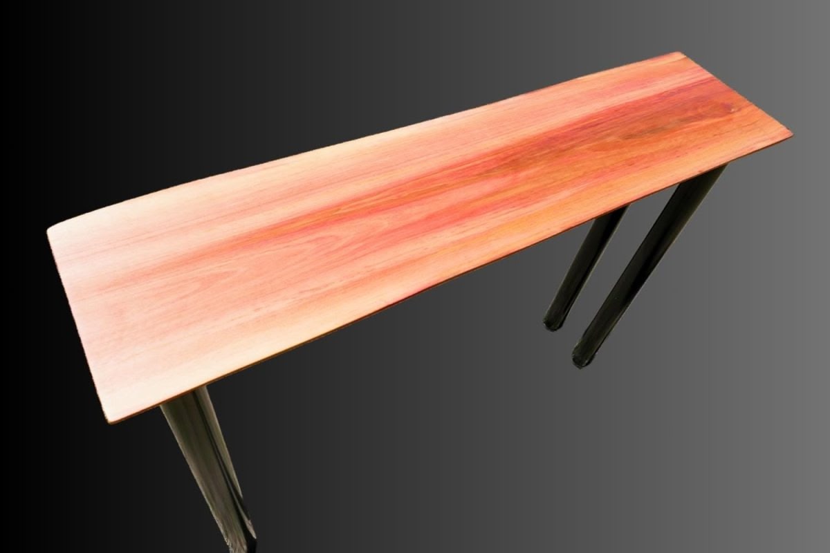 A pink redheart hardwood table with black round metal legs