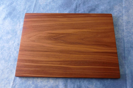 black walnut cutting board on a blue background