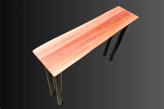 A pink redheart hardwood table with black round metal legs