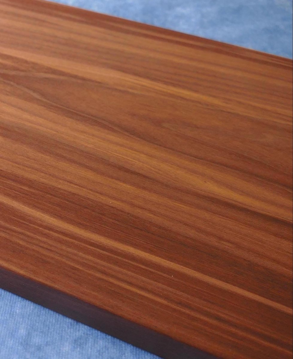 black walnut cutting board on a blue background