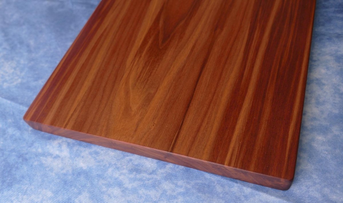 black walnut cutting board on a blue background