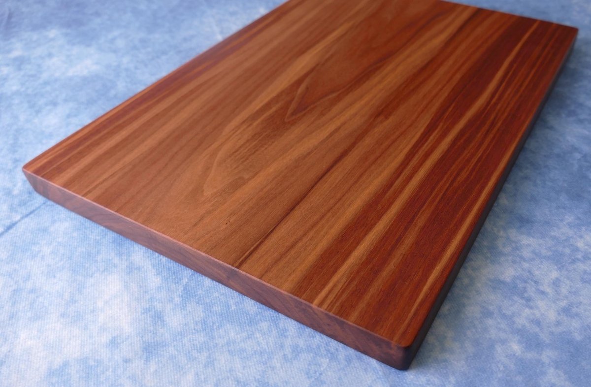 black walnut cutting board on a blue background