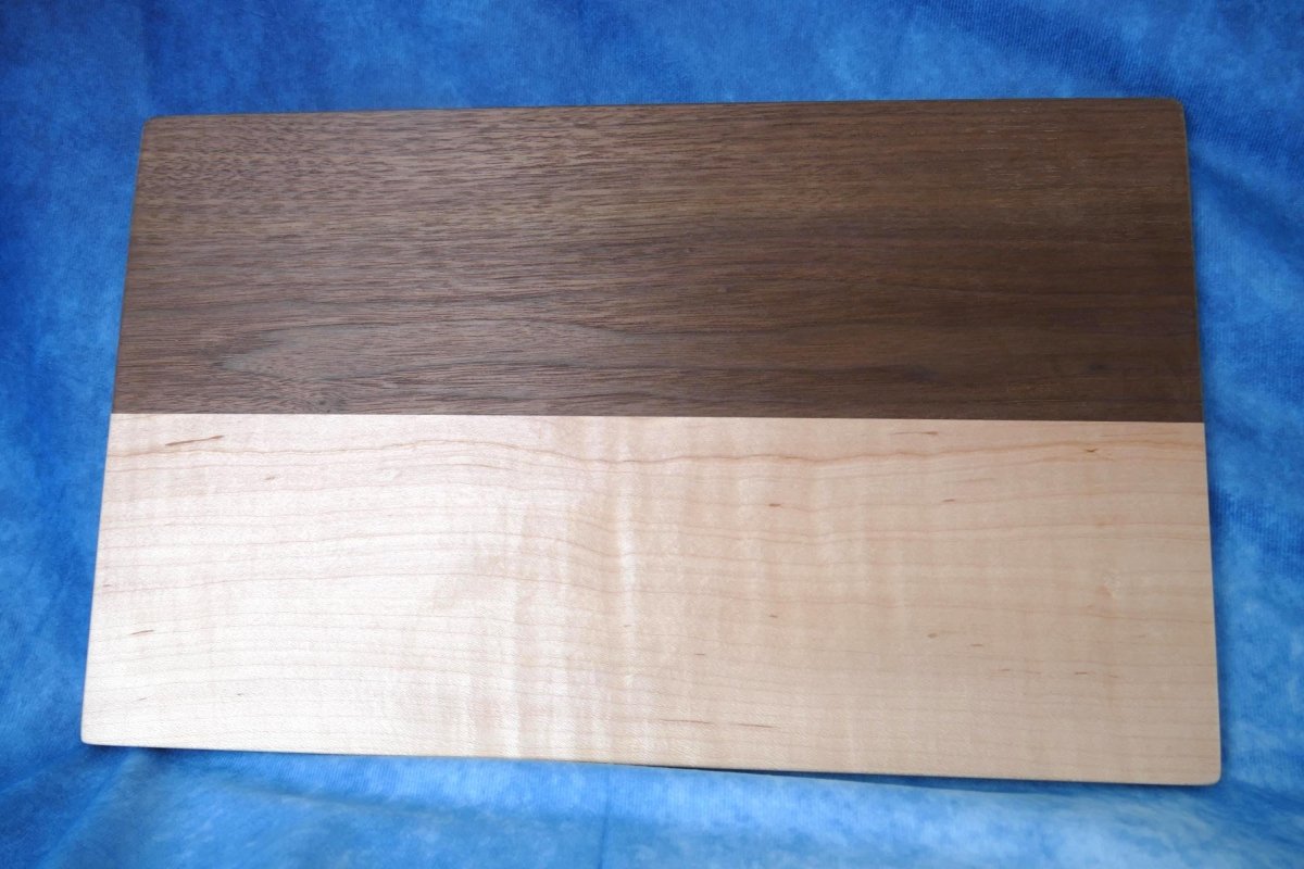 curly maple and walnut cutting board with a blue background