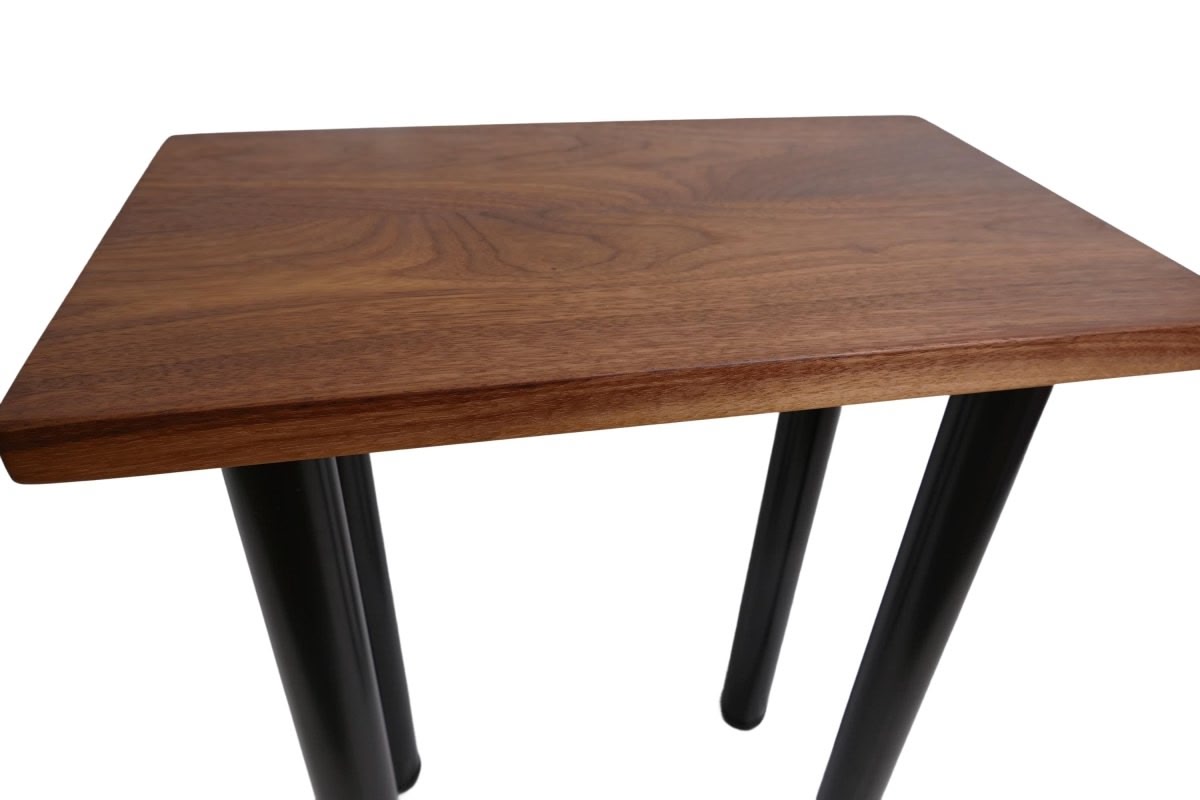 a black walnut table with round black metal legs on a white background