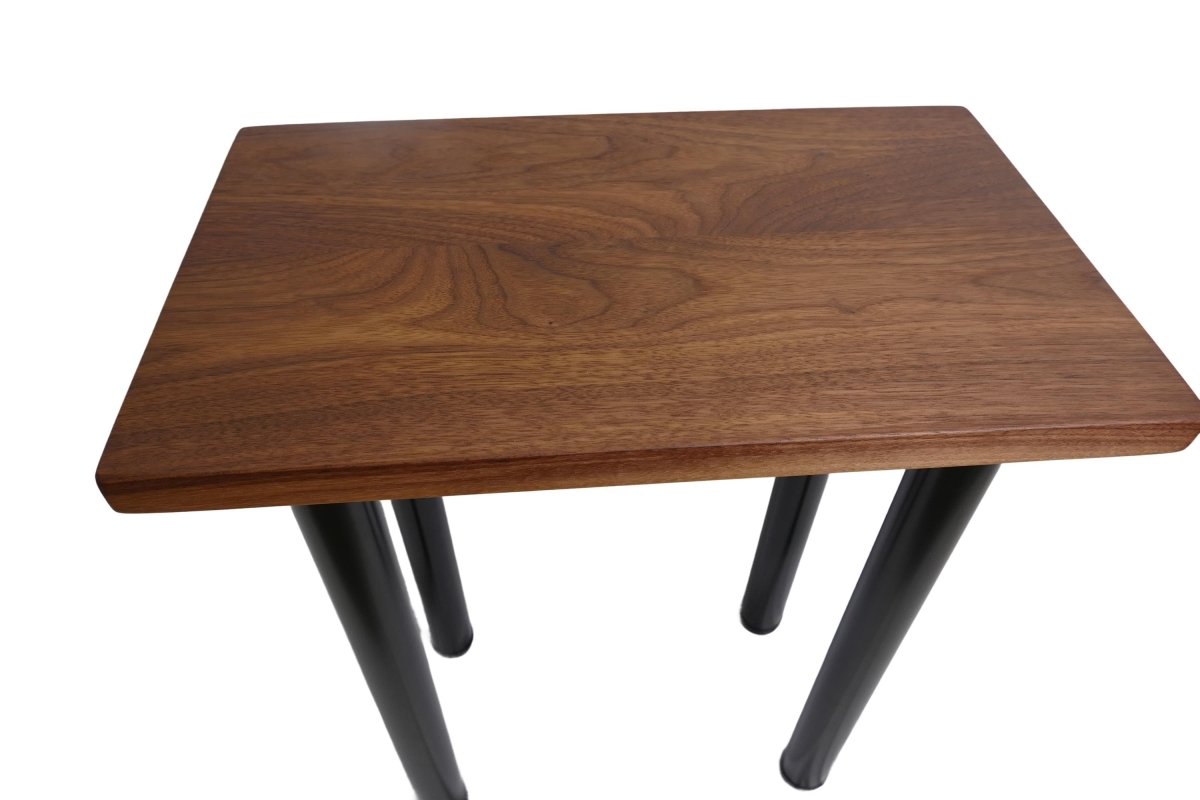a black walnut table with round black metal legs on a white background