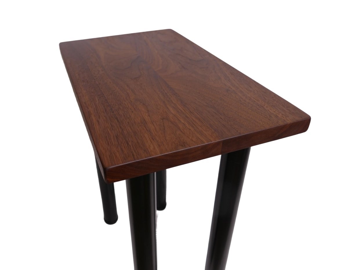 a black walnut table with round black metal legs on a white background