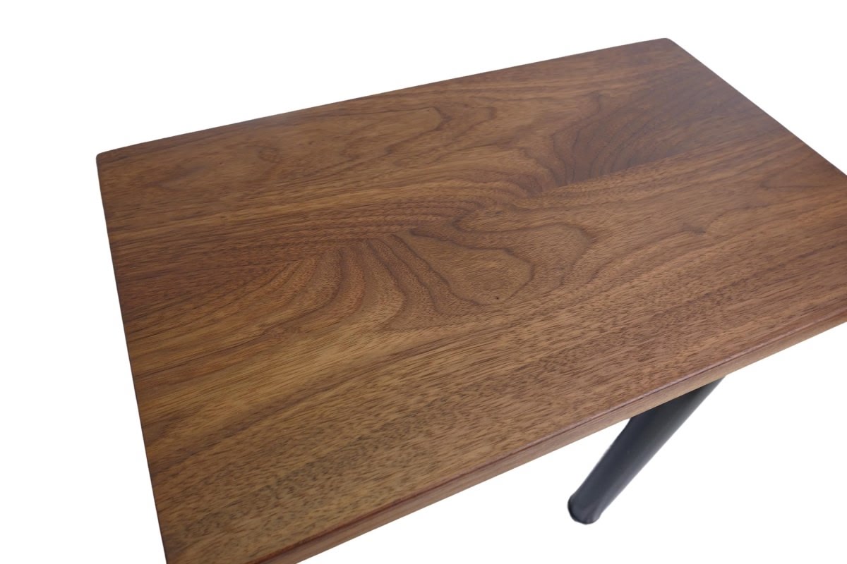 a black walnut table with round black metal legs on a white background