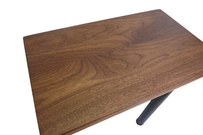a black walnut table with round black metal legs on a white background