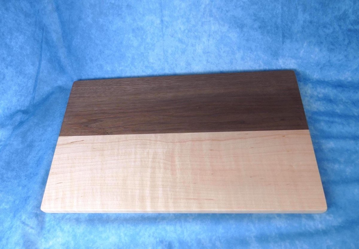 curly maple and walnut cutting board with a blue background