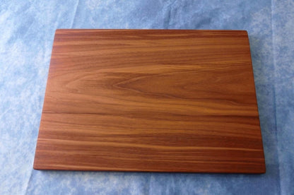 black walnut cutting board on a blue background