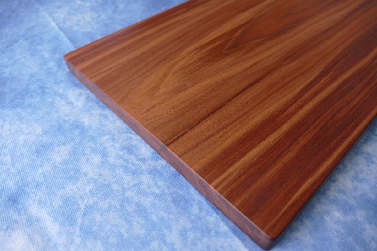 black walnut cutting board on a blue background