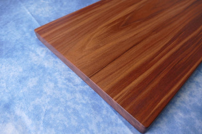 black walnut cutting board on a blue background