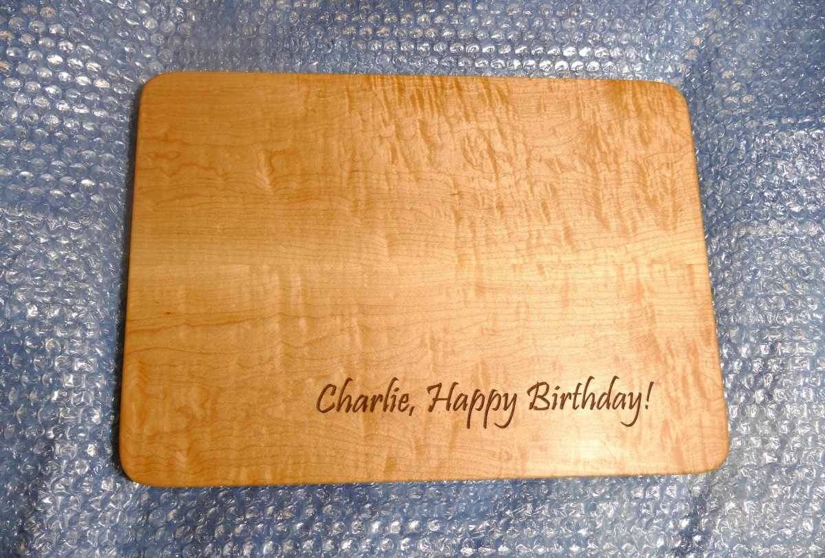 personalized, engraved, wooden cutting board made from hard curly maple hardwood on bubble wrap about to be packaged