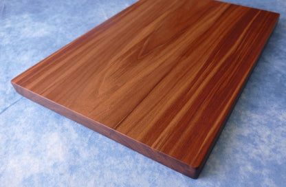 black walnut cutting board on a blue background