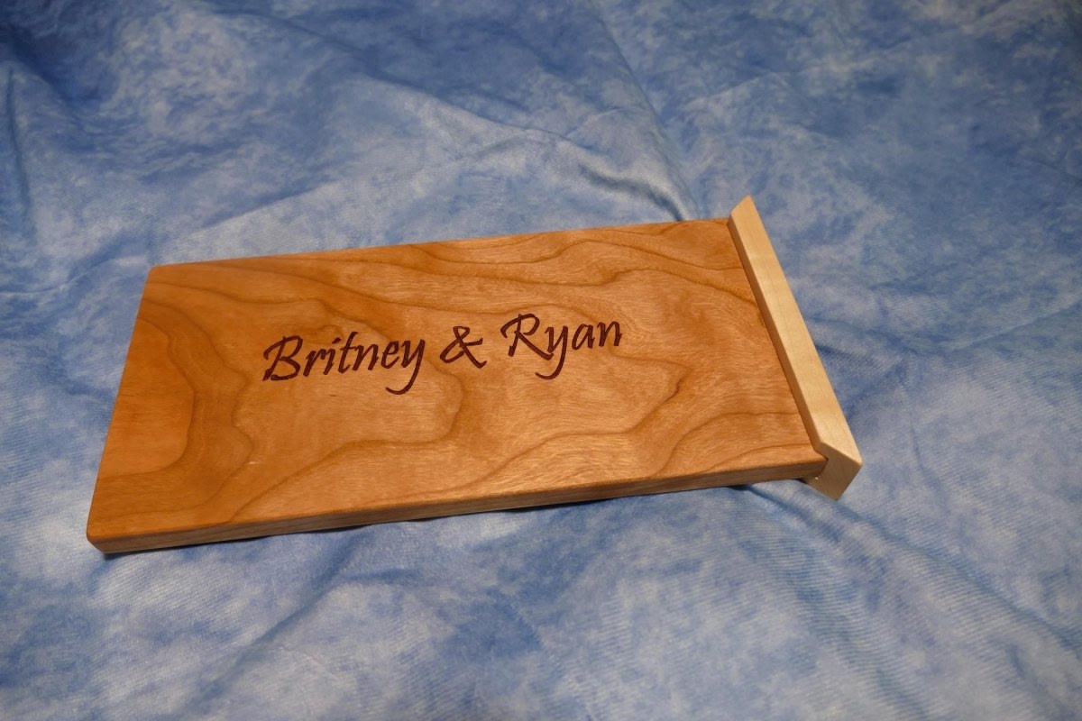an engraved curly cherry sliding lid sitting on a blue background